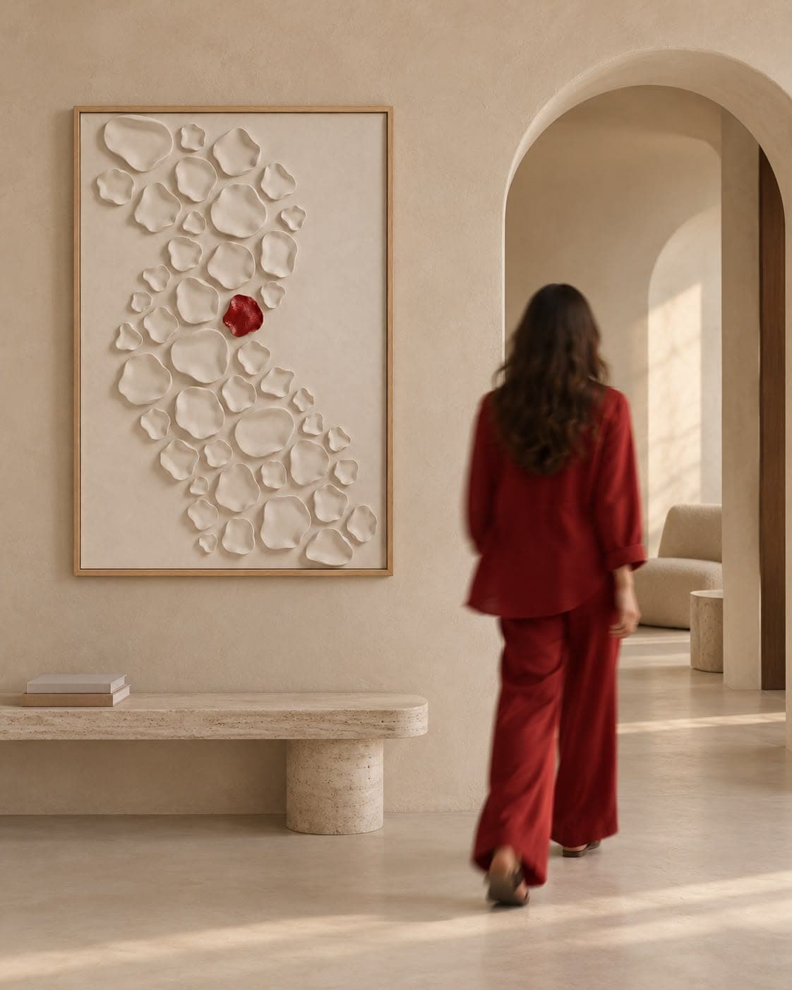 The Living Mark above a travertine bench as a woman in red walks past, towards an arched doorway